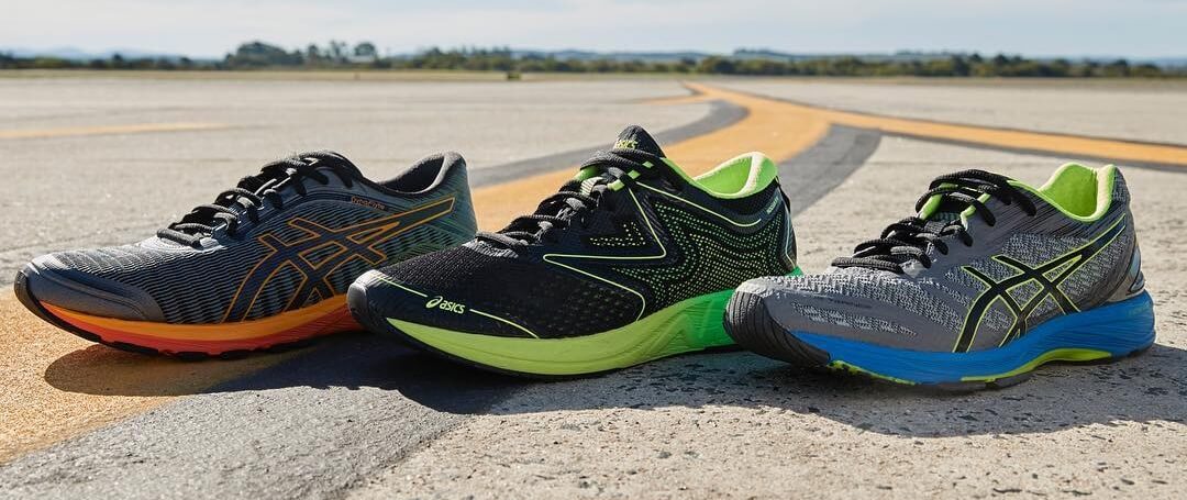 Кроссовки Asics - стоят по одной штуке на асфальте